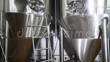 金属库里的啤酒。 现代啤酒酿造。 啤酒厂用不锈钢罐体进行啤酒发酵.. 4k
